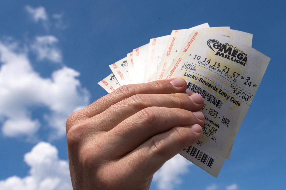 Alston Gore, 38, shows a handful of Mega Millions lottery tickets he purchased from a gas station on Freedom Drive in Charlotte, N.C., Thursday, July 28, 2022. Two tickets in North Carolina scored $1 million prizes in Friday’s drawing.