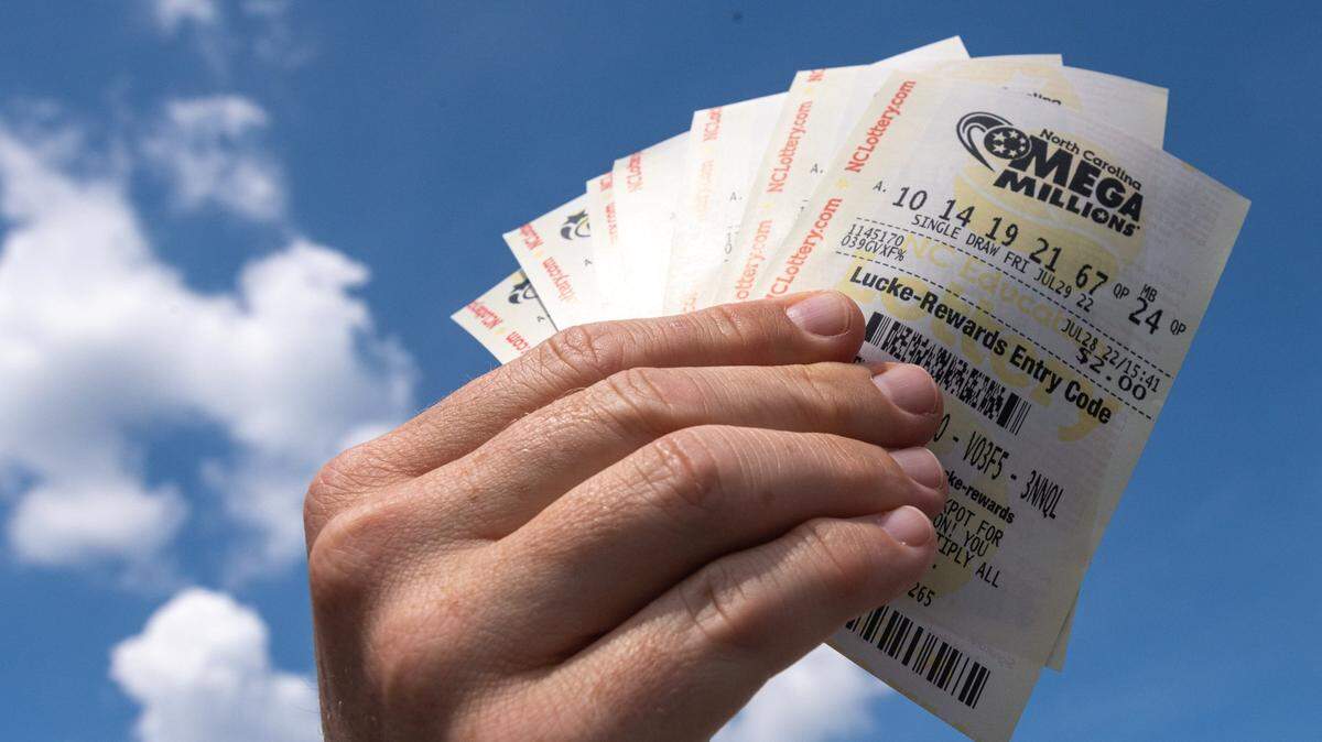 Alston Gore, 38, shows a handful of Mega Millions lottery tickets he purchased from a gas station on Freedom Drive in Charlotte, N.C., Thursday, July 28, 2022. Two tickets in North Carolina scored $1 million prizes in Friday’s drawing.