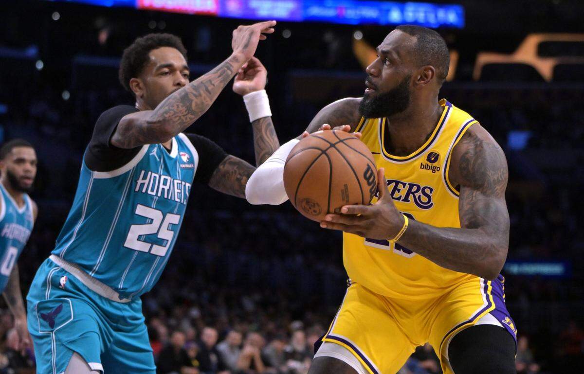Charlotte Hornets forward P.J. Washington (25) defends Los Angeles Lakers forward LeBron James (23) in the first half at Crypto.com Arena.