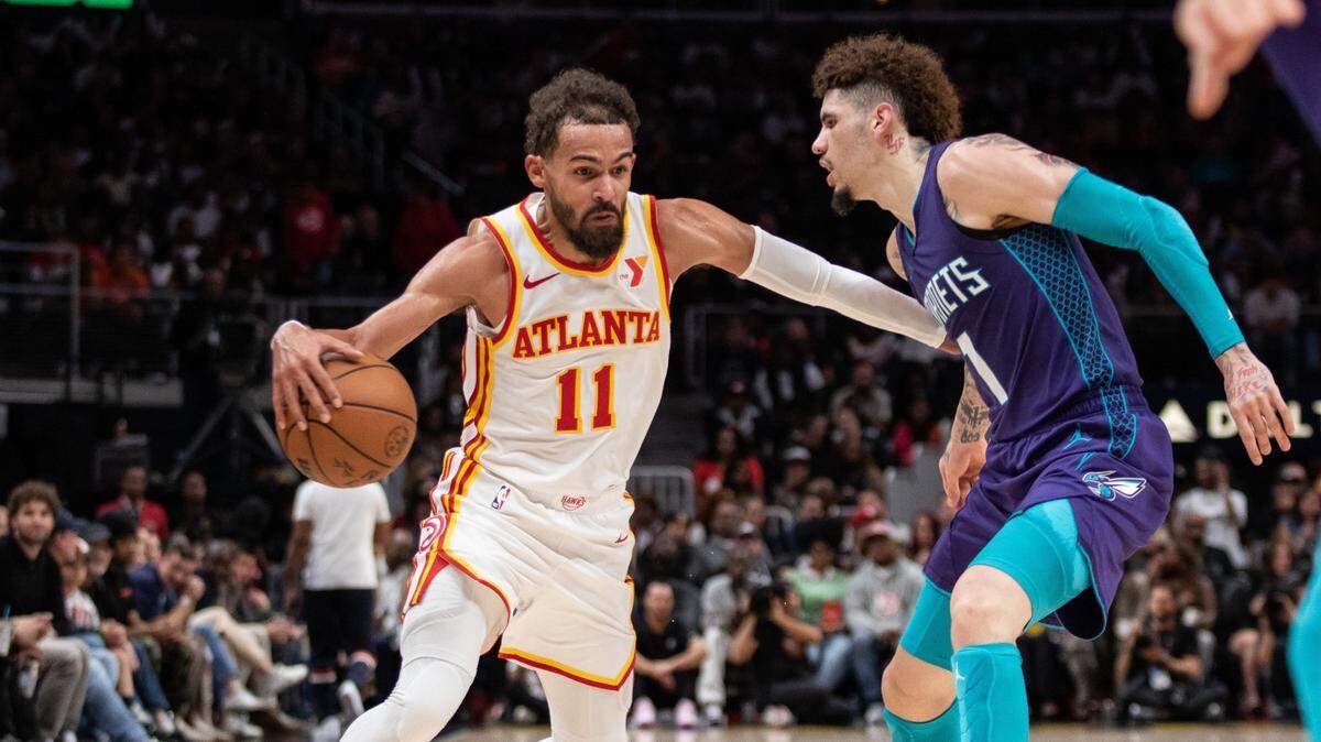 Atlanta Hawks guard Trae Young (11) protects the ball against Charlotte Hornets guard LaMelo Ball (1) during the fourth quarter at State Farm Arena.