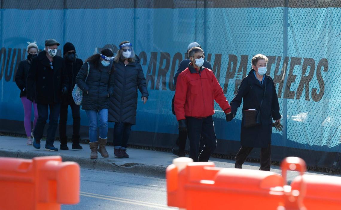 Pedestrians walk toward the Atrium Health vaccine clinic hosted at Bank of America Stadium on Friday, January 29, 2021. Atrium Health, Honeywell, Tepper Sports & Entertainment and Charlotte Motor Speedway formed a public-private partnership that expects to vaccinate 19,000 people at the Friday through Sunday event.