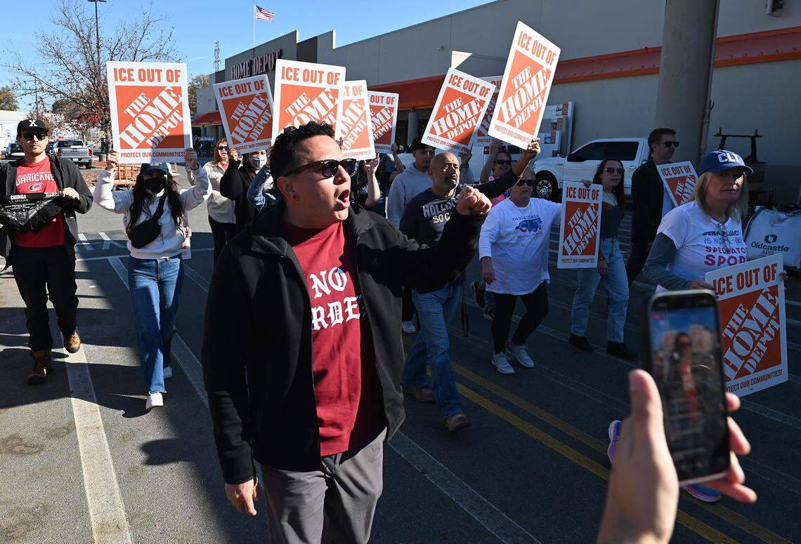 Protesters walk down outside the Home Depot on North Wendover Road in Charlotte on Wednesday, November 19, 2025. 