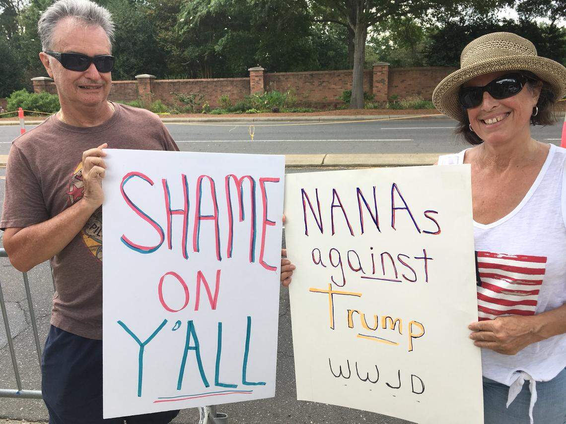 David and Beth Lynn of Huntersville, who held signs near Carmel Country Club before President Donald Trump attended a fundraiser there Friday, say the president is dishonest and divisive.