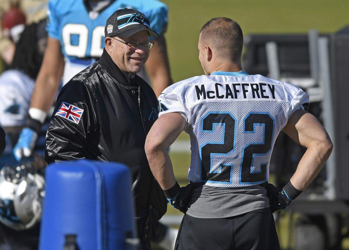 Carolina Panthers owner David Tepper talks with running back Christian McCaffrey (22) during a 2019 practice.