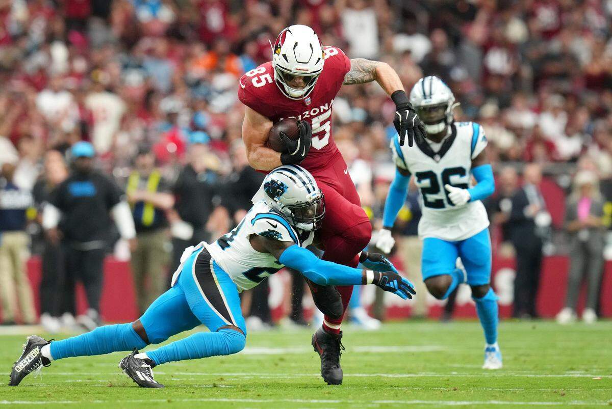 Arizona Cardinals tight end Trey McBride (85) is tackled by Carolina Panthers safety Nick Scott (21) after making a first-down catch at State Farm Stadium on Sept 14, 2025.