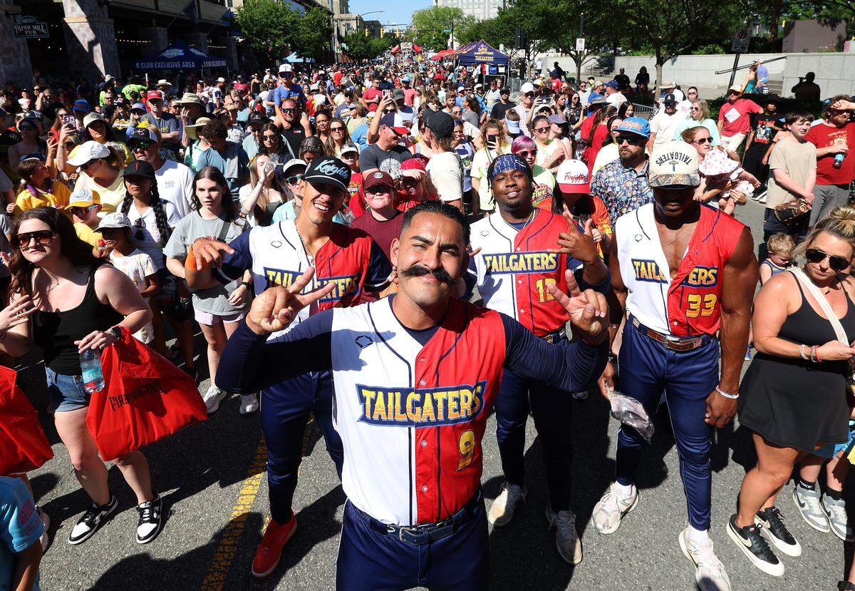 Texas Tailgaters Nick Lopez, center, is joined by a few of his teammates to dance with fans during pregame activities outside Truist Field in Charlotte, NC on Thursday, June 4, 2026. The Texas Tailgaters played the Firefighters in Banana Ball action at Truist Field. 