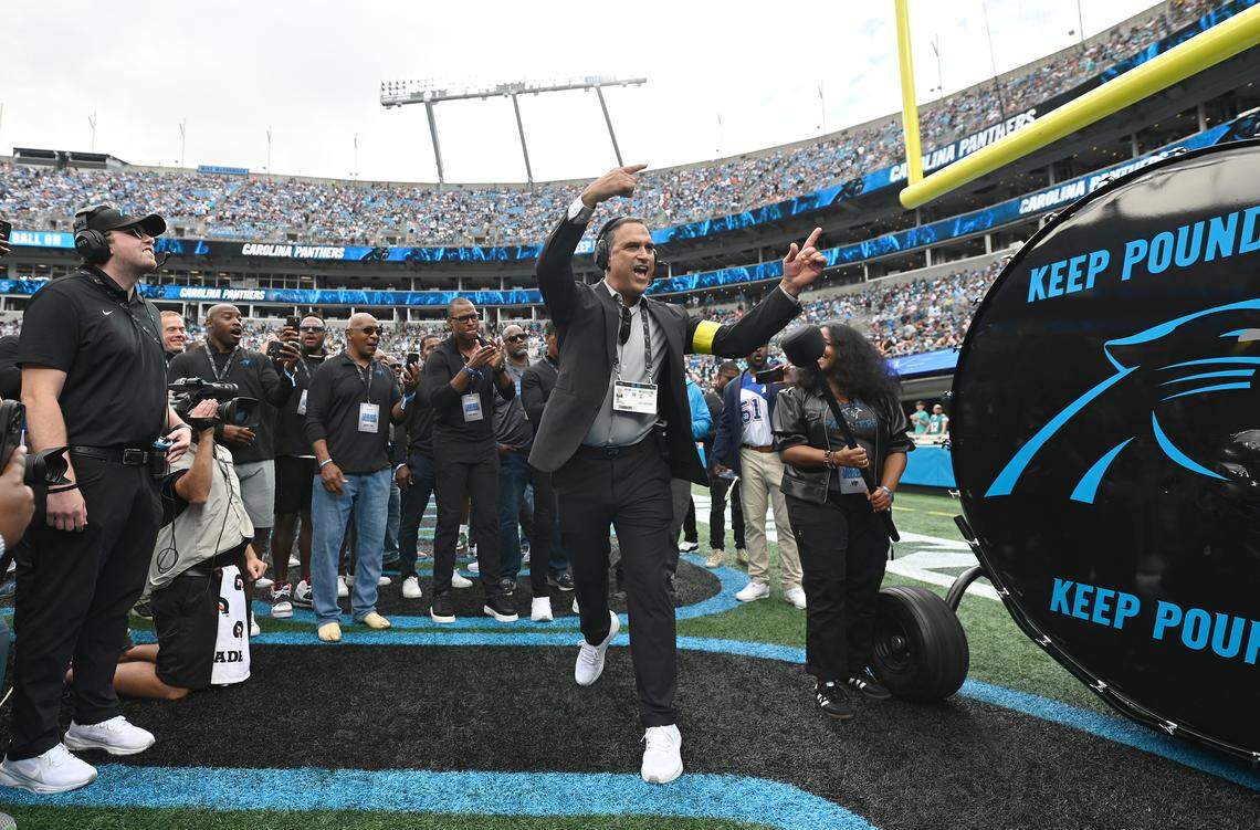 Miguel Vargas, director of entertainment for the Carolina Panthers, looks to energize the former Panther players gathered around the “Keep Pounding” drum on Oct. 5, 2025. The “Keep Pounding” drummer changes each week, but for this pregame was Melanie Mills, the widow of the late Panthers linebacker Sam Mills.