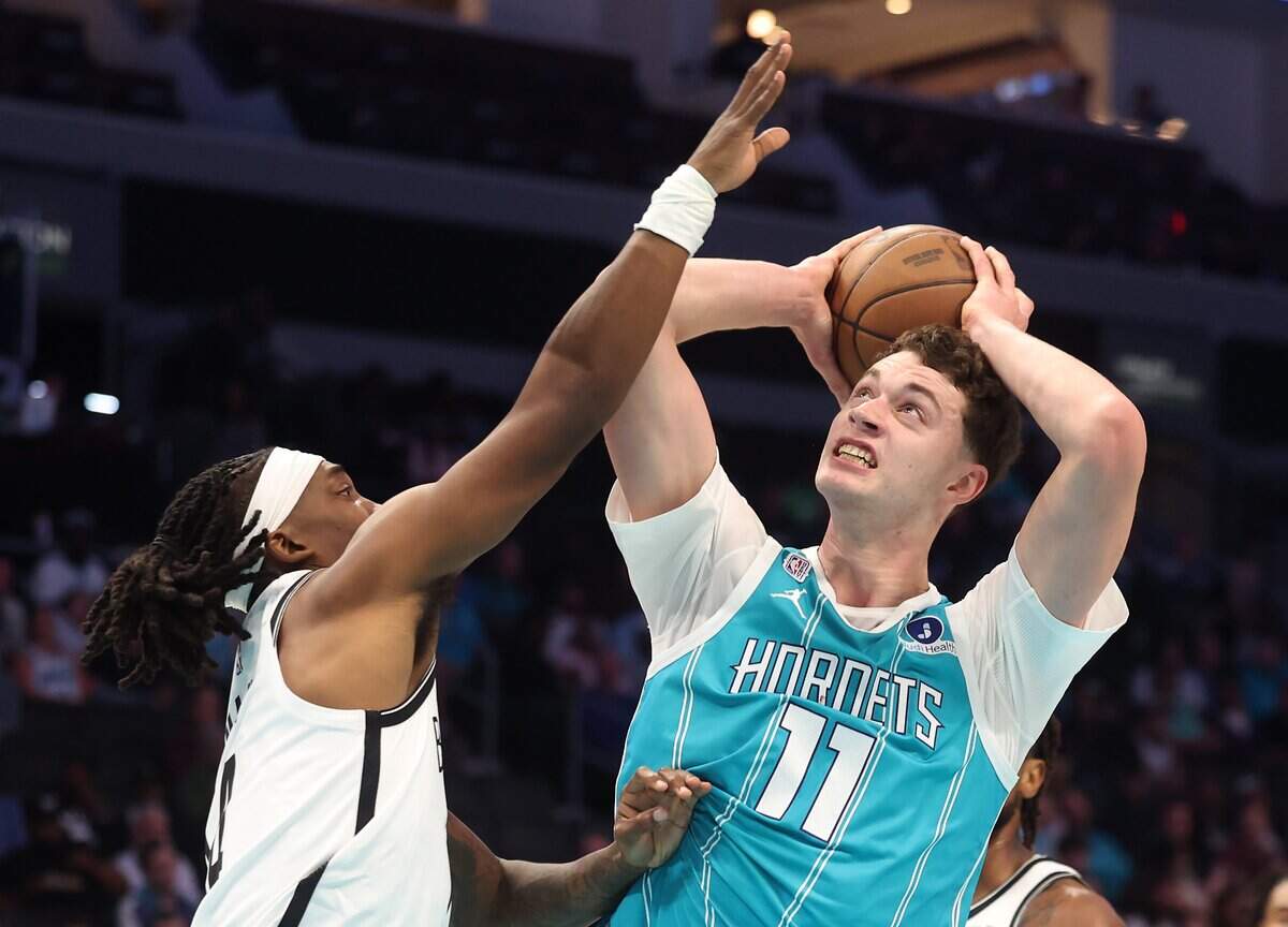 Charlotte Hornets center Ryan Kalkbrenner, right, fights to get a shot off in the lane against the Brooklyn Nets on Wednesday, Oct. 22, 2025 at Spectrum Center in Charlotte. The Hornets defeated the Brooklyn Nets 136-117.