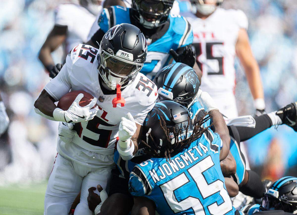 Atlanta Falcons cornerback Natrone Brooks, left, is tackled by a host of Carolina Panthers defenders at the Bank of America Stadium in Charlotte on Sunday, September 21, 2025.