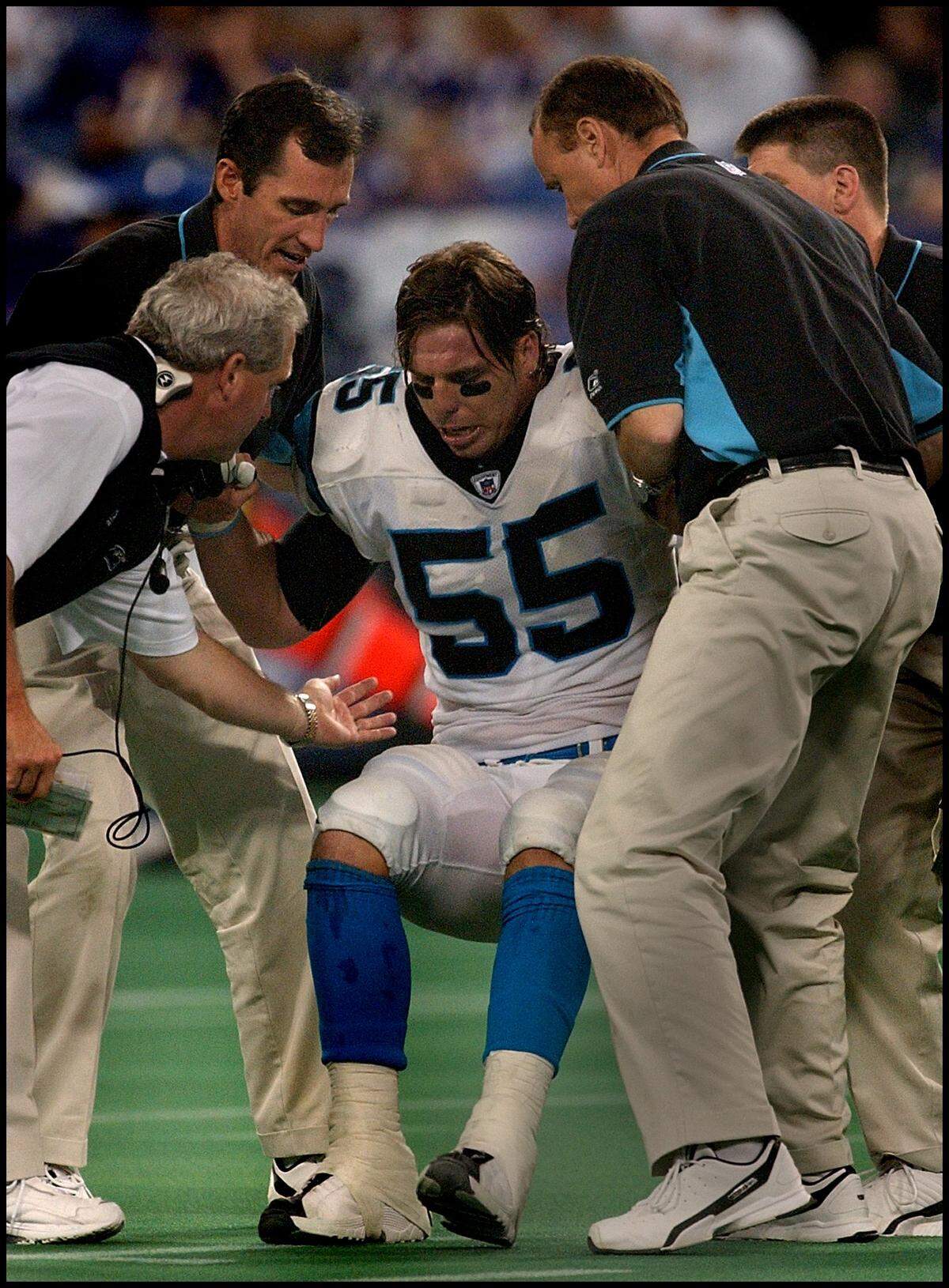 In 2002, Panthers linebacker Dan Morgan was helped to his feet after an injury by a member of the team’s training staff and head coach John Fox (left).