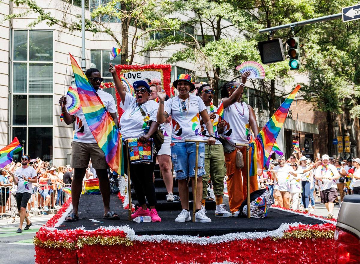 Wells Fargo float participants cheer and wave rainbow flags during the Charlotte Pride Festival & Parade on Sunday, Aug. 18, 2024
