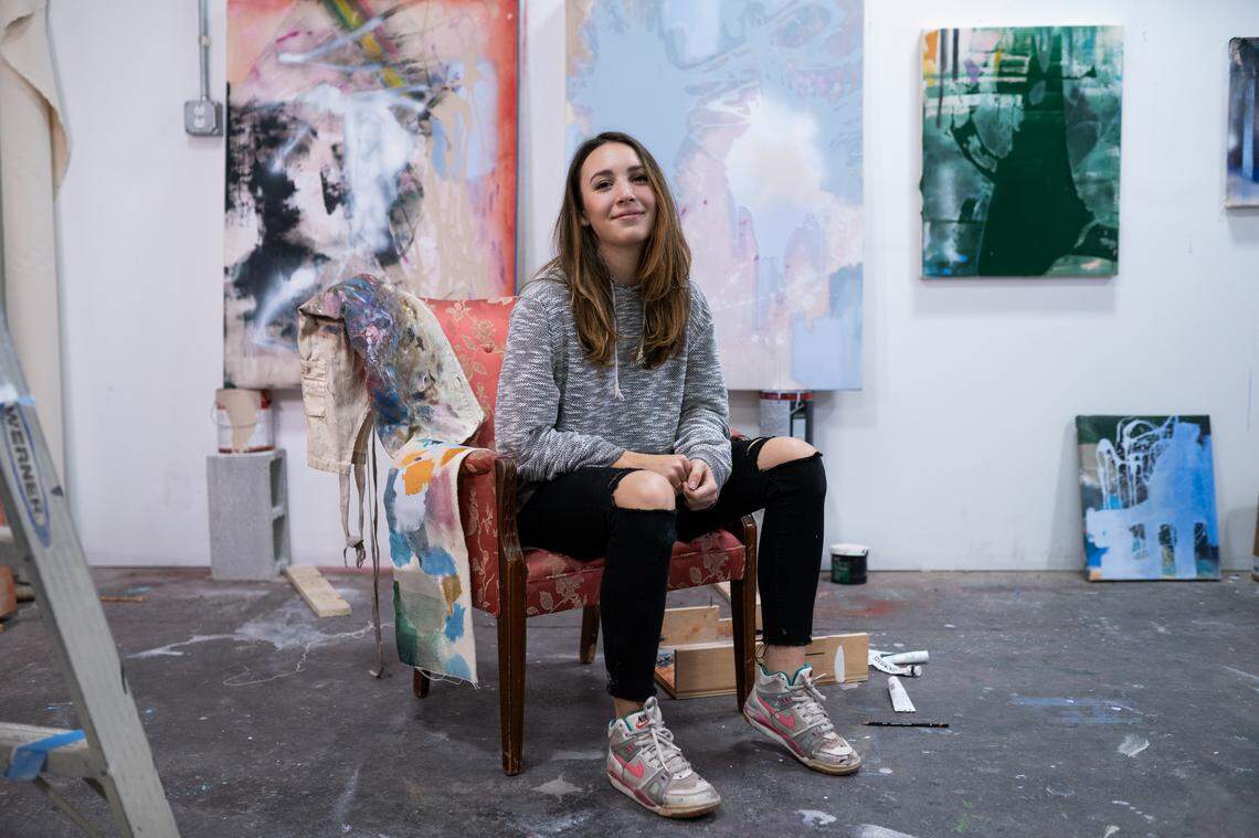 Artist Katherine Boxall, 26, sits in her West Charlotte studio surrounded by some of her paintings.
