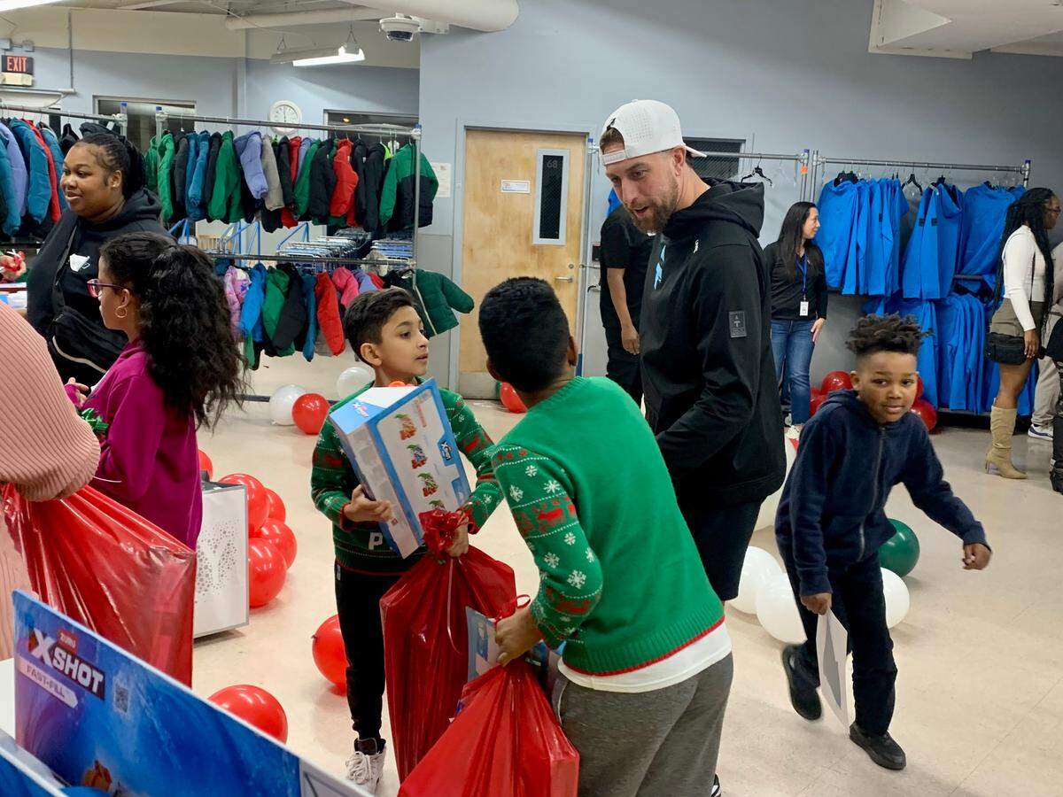 Carolina Panthers WR Adam Thielen chats with children during an holiday event at Crisis Assistance Ministry in Charlotte, North Carolina on Thursday, Dec. 19, 2024.
