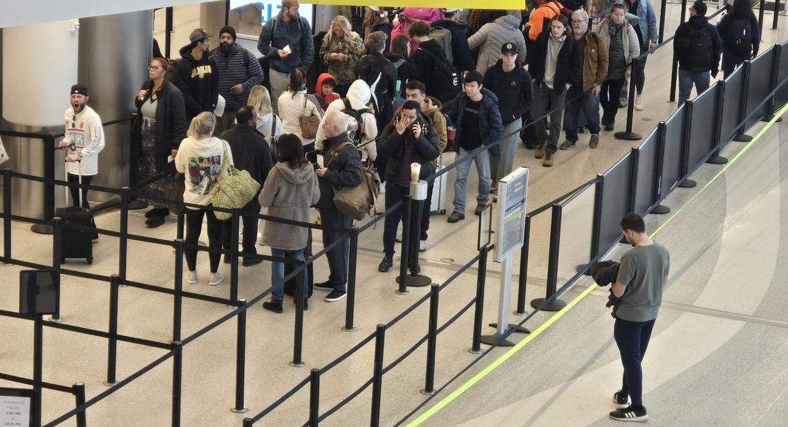 Passengers in a security line at Charlotte Douglas International Airport Tuesday morning. Many were facing delays of their American Airlines flights after a vendor technical issue forced an hour-long ground stop on Christmas Eve, one of the busiest travel days of the year.