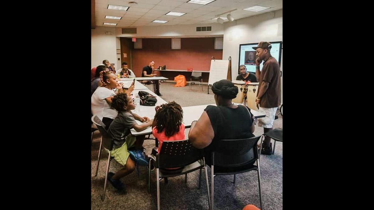 Guerilla Poets members Tarik Kiley, left, and Jah Smalls, right, lead a workshop and perform at West Boulevard Library in Charlotte.