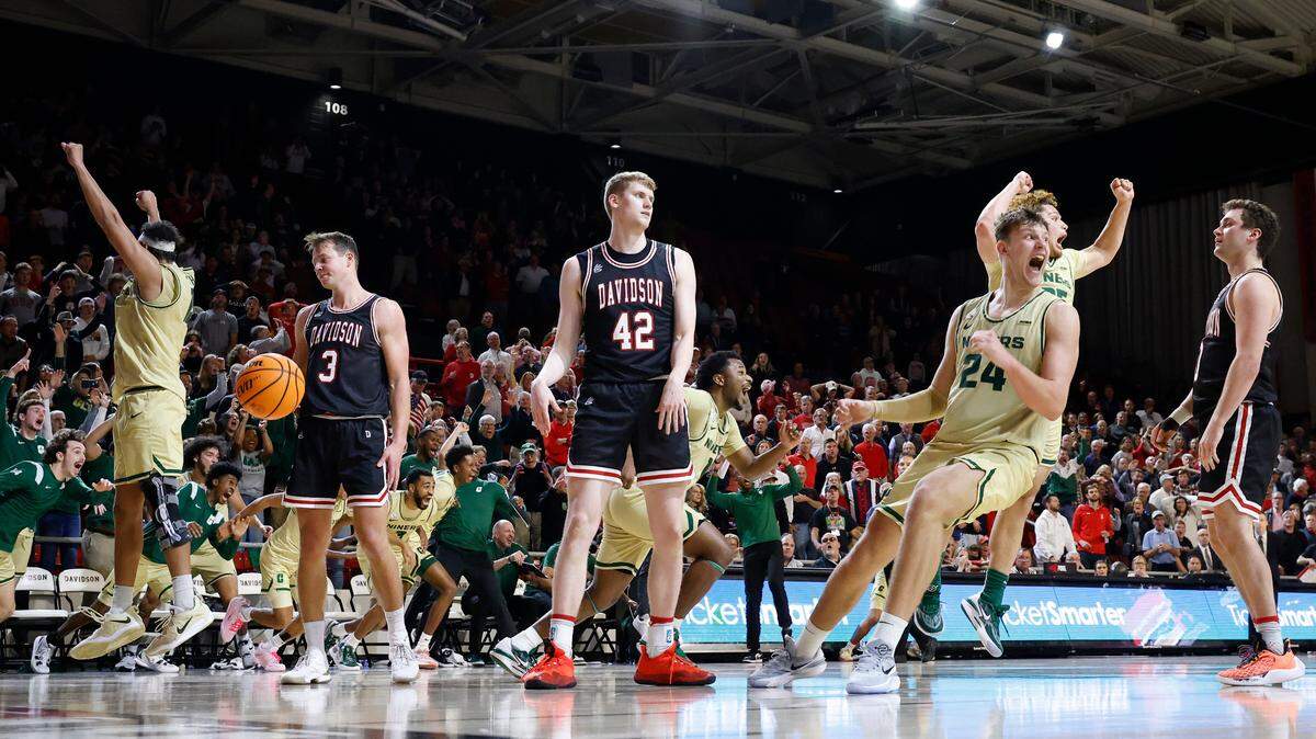 The Charlotte 49ers celebrate their 68-66 overtime win over the Davidson Wildcats during a game at Belk Arena in Davidson, N.C., Tuesday, Nov. 29, 2022.