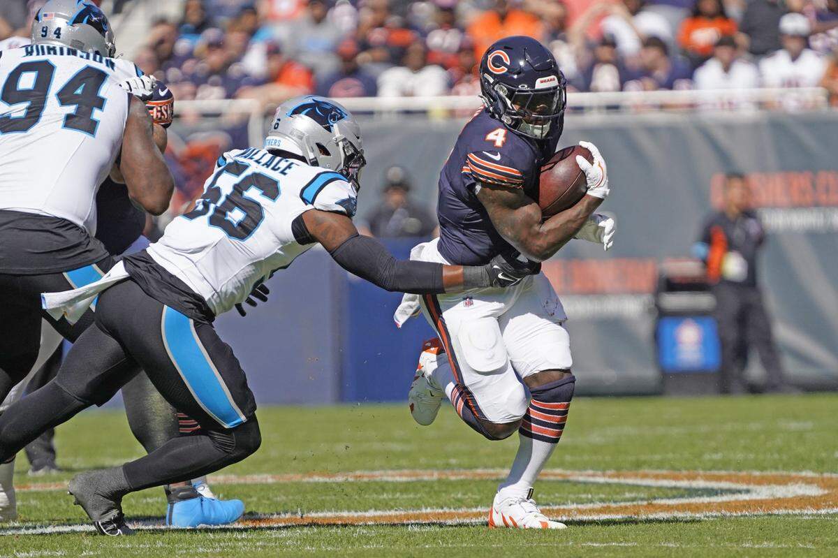 Oct 6, 2024; Chicago, Illinois, USA; Chicago Bears running back D'Andre Swift (4) runs the ball as Carolina Panthers linebacker Trevin Wallace (56) tackles him during the first half at Soldier Field. Mandatory Credit: David Banks-Imagn Images