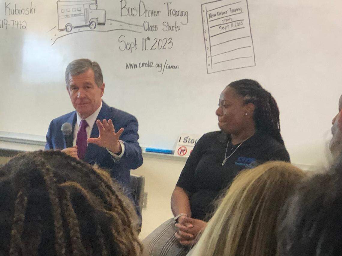 Gov. Roy Cooper on Tuesday talks with a group of Charlotte-Mecklenburg Schools bus drivers and transportation employees during a visit to also announce $1 million to help with school bus training — an amount he says isn’t enough.