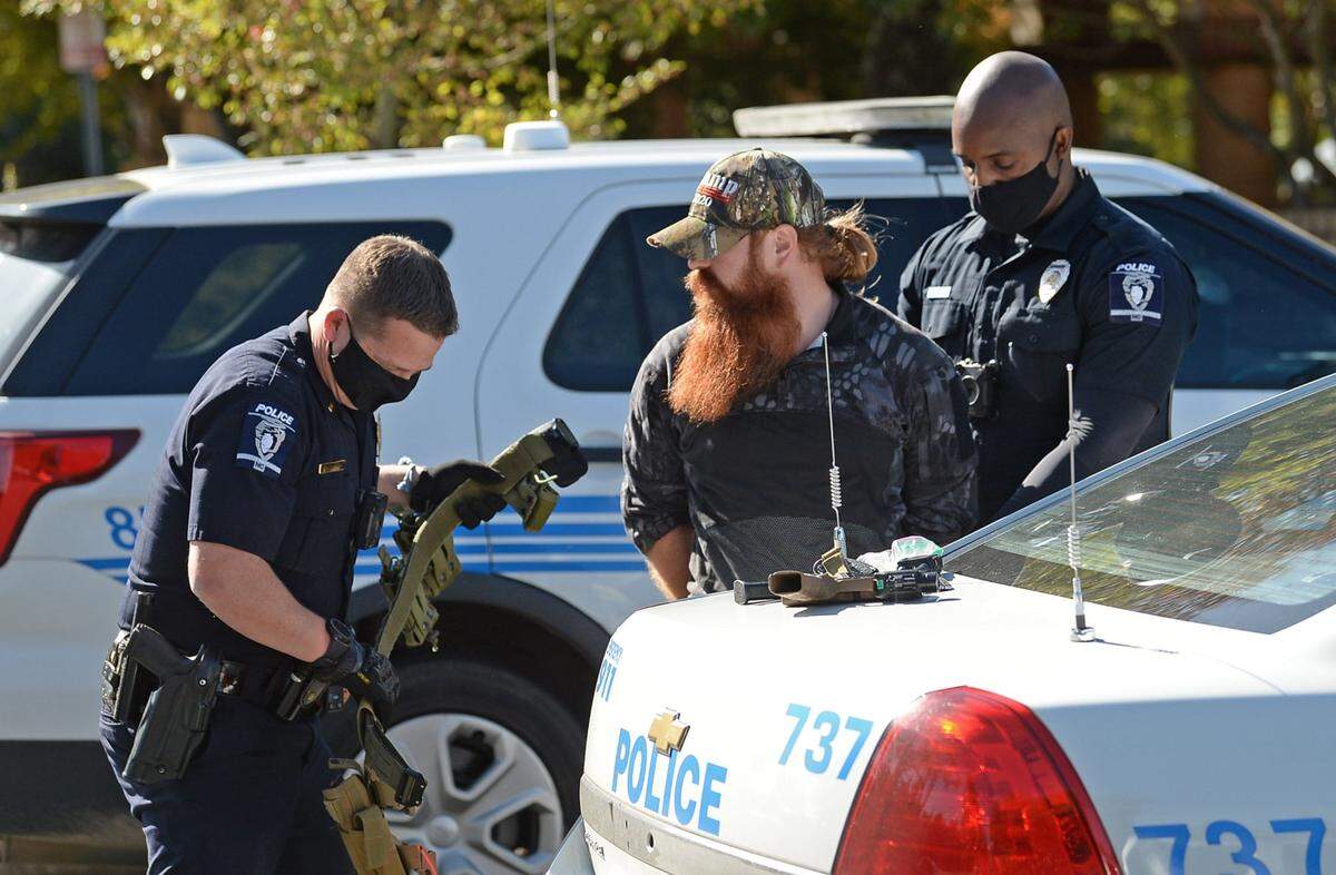 Charlotte police officers search a man following his arrest on Tuesday, November 3, 2020. The man who identified himself as, Justin, came to Precinct 212 at Oasis Shriners at 604 Doug Mayes Place in the University City area of Charlotte, NC with a firearm on his right hip.
