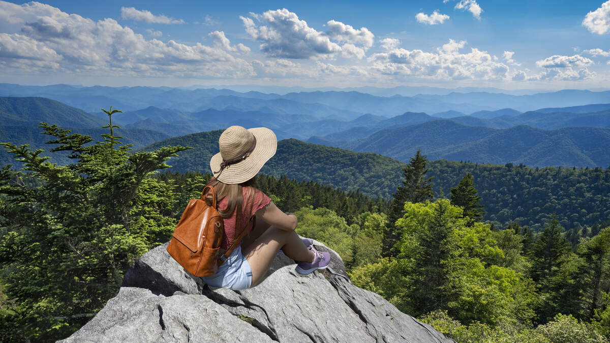Woman relaxing on top of mountain near the Blue Ridge Parkway in North Carolina.