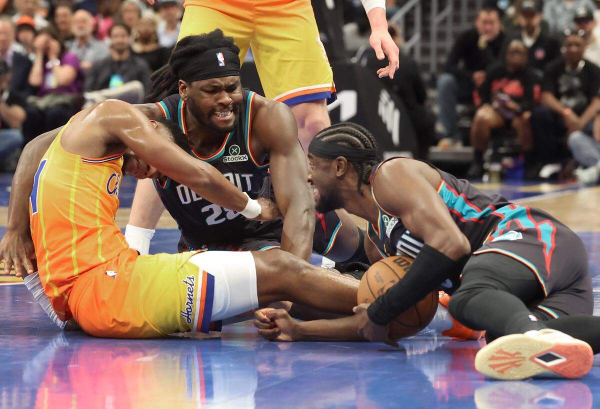 Charlotte Hornets guard Brandon Miller, left, is pushed down by Detroit Pistons center Isaiah Stewart, center, as Pistons teammate guard Caris LeVert, right, gains control of a loose ball during action on Friday, April 10, 2026 at Spectrum Center in Charlotte, NC. The Pistons defeated the Hornets 118-100.