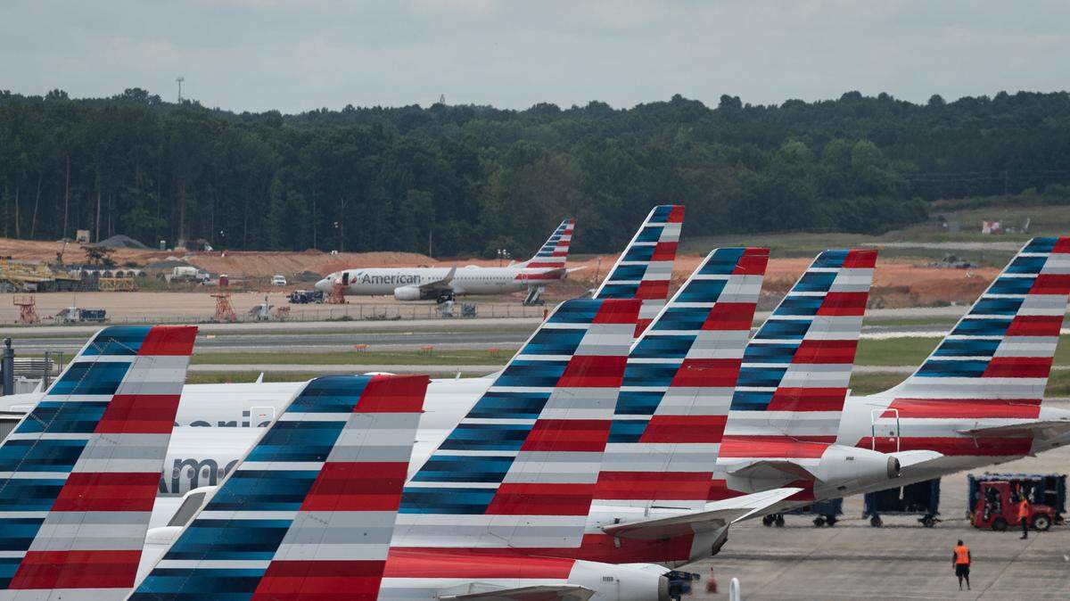 A row of American Airlines jets as seen from the 7th-floor roof of the hourly parking structure Friday morning, July 1, 2022 at the Charlotte Douglass International Airport.