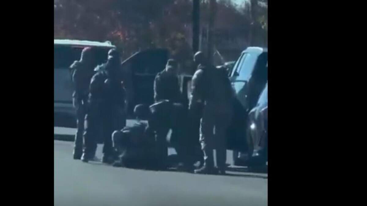 Masked agents surround Charlotte resident Cristobal Maltos after Maltos said the agents shattered his windshield, pulled him from his car and threw him to the asphalt on South Tryon Street near Arrowood Road on Monday, Nov. 17, 2025.
