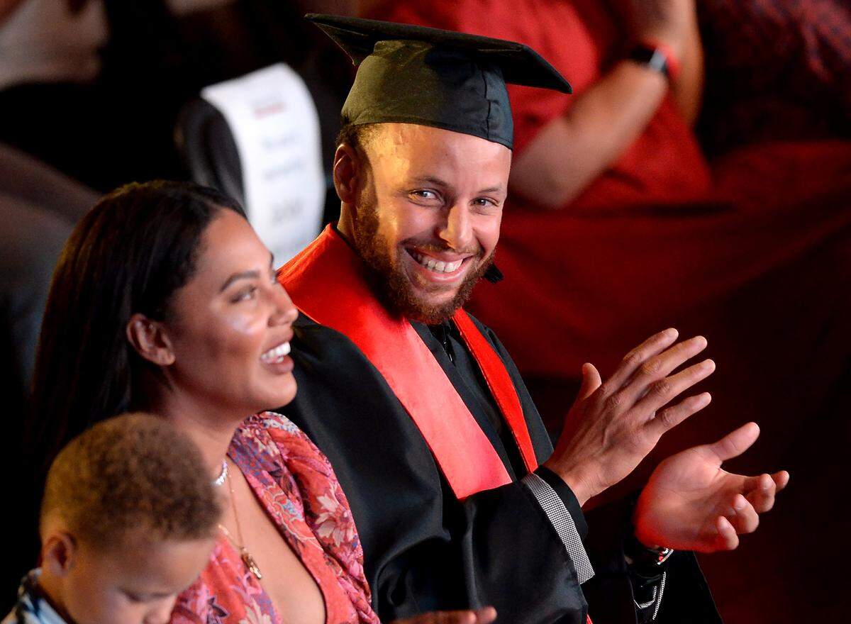 Stephen Curry sits with his wife, Ayesha at his graduation ceremony at Davidson College in 2022.