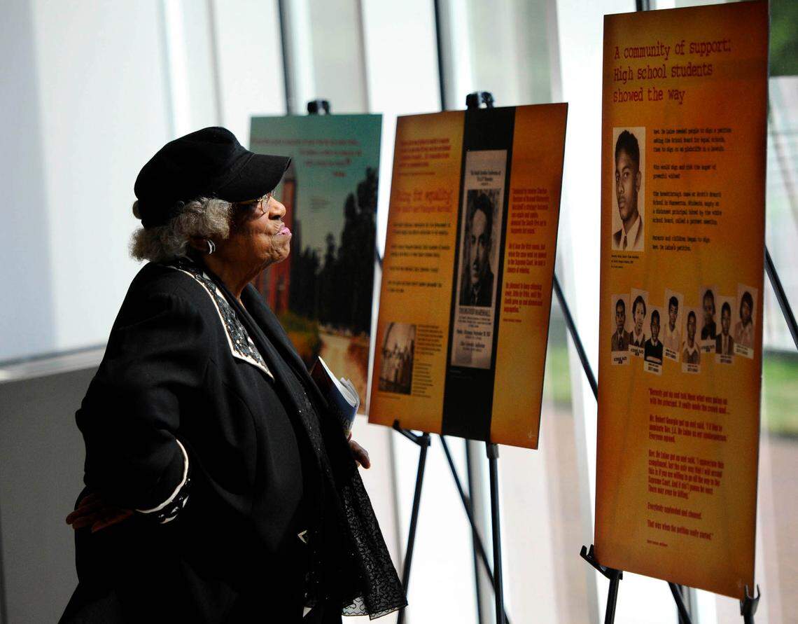 Thereasea Elder reads posters from The Museum of the New South’s  “Courage” exhibit, while attending a reception in the UNC Charlotte Center City lobby for the 60-Year Celebration of Brown v. Board of Education: The Impact on Charlotte and the Carolinas on May 12, 2014. .The event, sponsored by The Urban Education Collaborative at UNC Charlotte under the direction of Dr. Chance W. Lewis and the College of Education at UNC Charlotte under the direction of Dean Ellen McIntyre. 