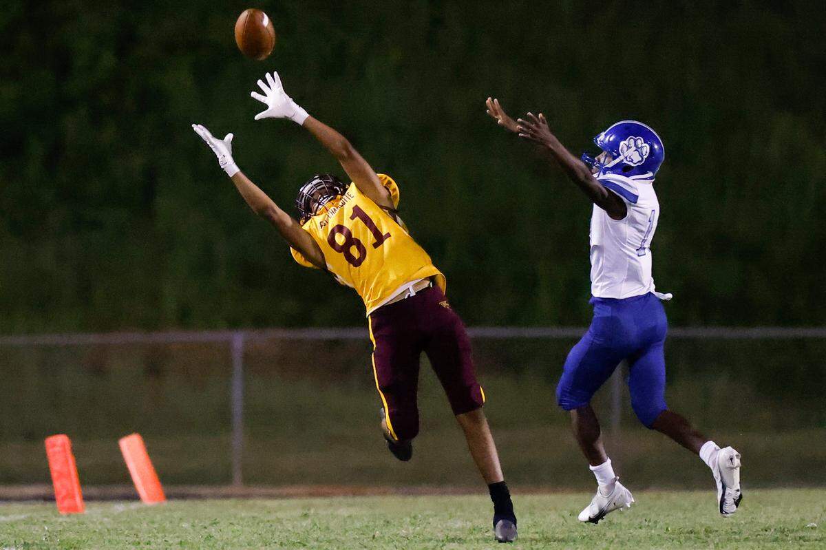 West Charlotte’s Rakim Finch (81) jumps to catch a pass with pressure from Garinger Malachi McCord (13) during a game at Waddell High School in Charlotte, N.C., Thursday, Sept. 8, 2022. West Charlotte beat Garinger 48-8.