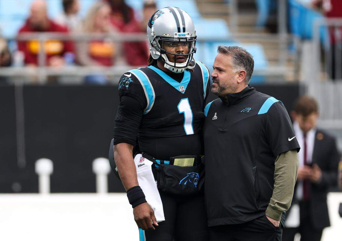 Carolina Panthers Cam Newton, left, talks to coach Matt Rhule during warm ups before the game against Washington Football Team at the Bank of America Stadium in Charlotte, N.C., on Sunday, November 21, 2021.