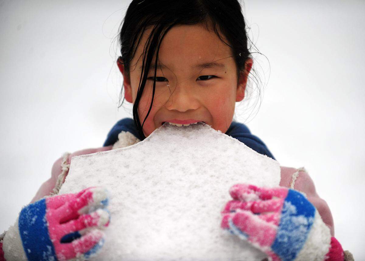 Evangelina Dong, 8, tastes ice in Lake Park, N.C. in January 2011