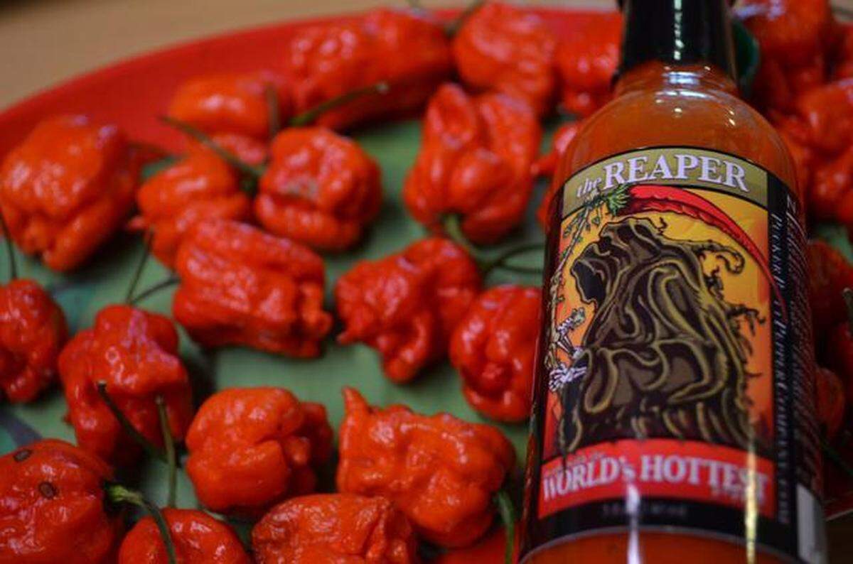 “Smokin’ Ed’s Carolina Reaper” chili peppers and a bottle of the sauce made using its extract.