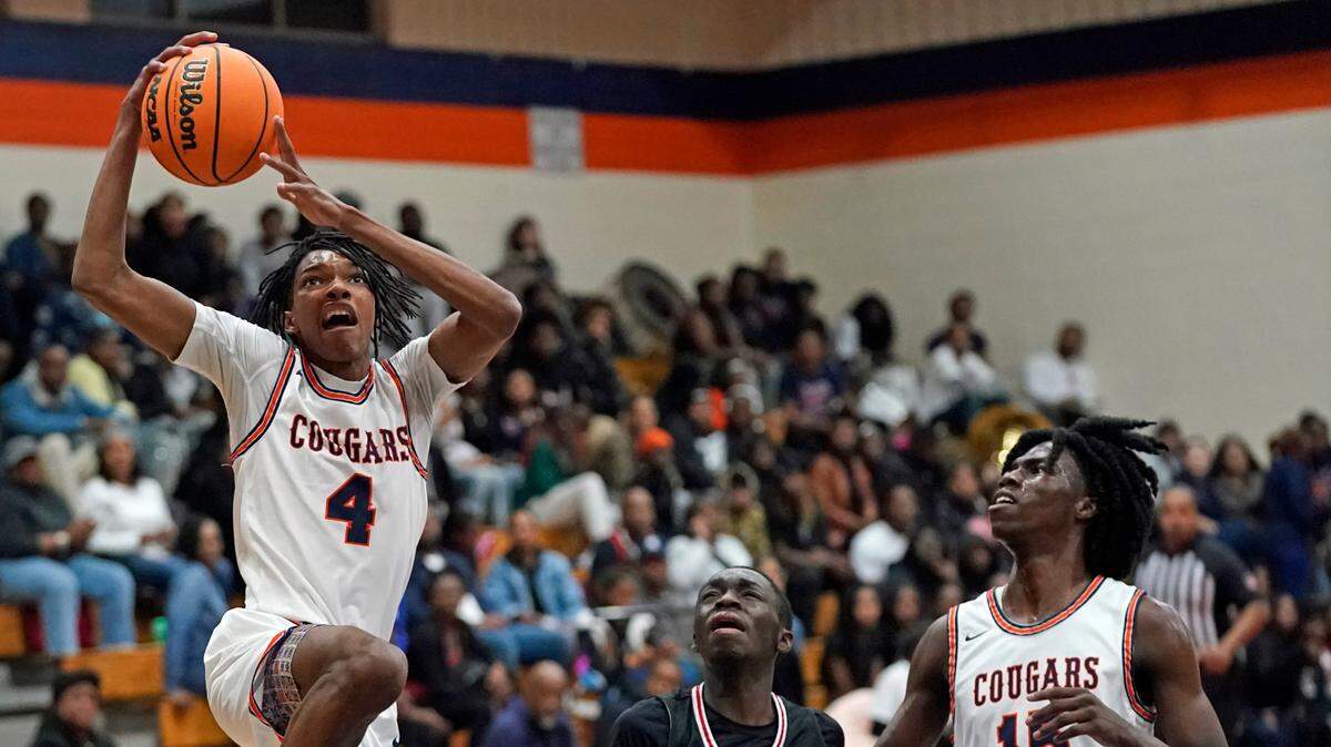 Chambers High’s Tarrie Bouie III, left, drives for a dunk as Butler High’s Terrance Badio, center, and Chambers High’s Cameron Thompson look on during the first half of their non-conference varsity boys basketball game Friday, Dec. 13, 2024, in Charlotte, N.C. (CREDIT: Bill Kiser/Special to the Charlotte Observer)
