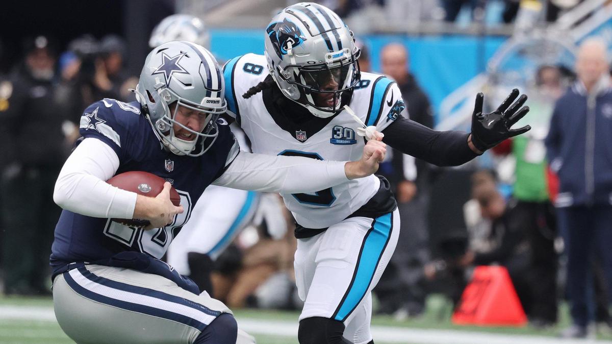 Panthers Jaycee Horn (8) tries to take down Cowboys QB Cooper Rush.
