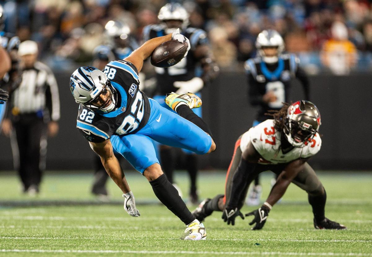 Carolina Panthers tight end Tommy Tremble, left, avoids a tackle by Tampa Bay Buccaneers cornerback Tavierre Thomas at the Bank of America Stadium in Charlotte, N.C., on Sunday, December 1, 2024.