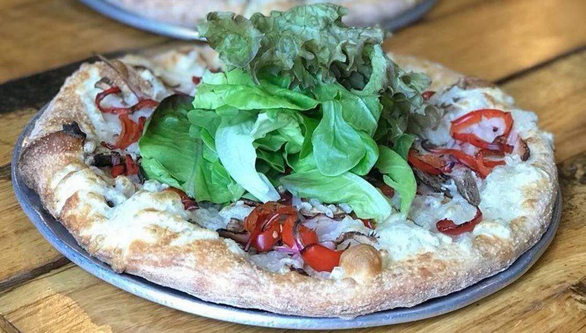 The vegan She-Rex pizza has mushrooms, onion and peppers topped with greens.