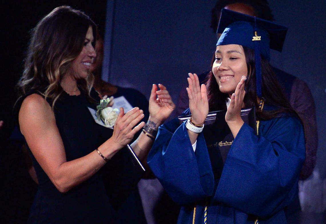 MC Hildreth, founder and head of school of The Nest Academy, left, and 2020 graduate Emily Adrong, right, applaud her graduating during graduation exercises on Friday, June 4, 2021.