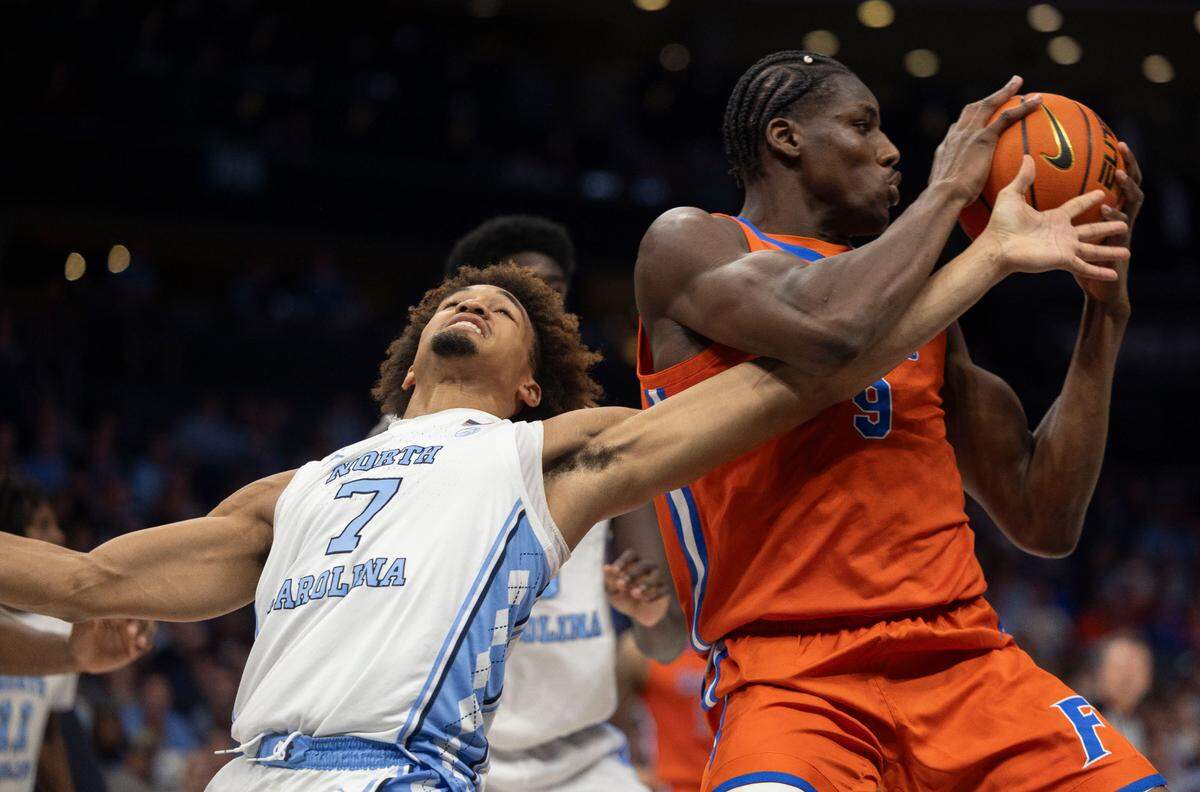 Florida’s Reuben Chinyelu (9) secures an offensive rebound from North Carolina’s guard Seth Trimble (7) in the first half during the Jumpman Invitational on Tuesday, December 17, 2024 at the Spectrum Center in Charlotte, N.C.
