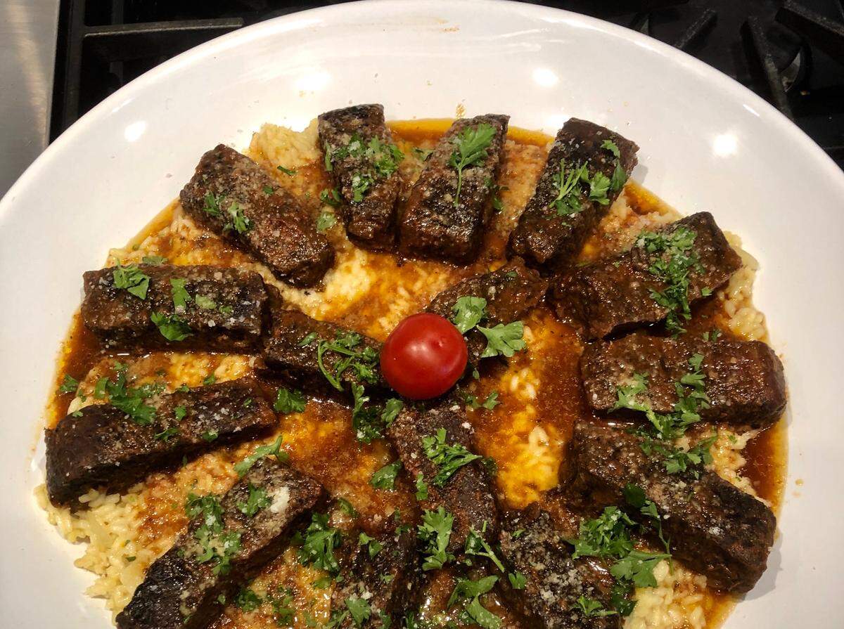 A restaurant style dinner at home with braised short ribs over risotto Milanese.