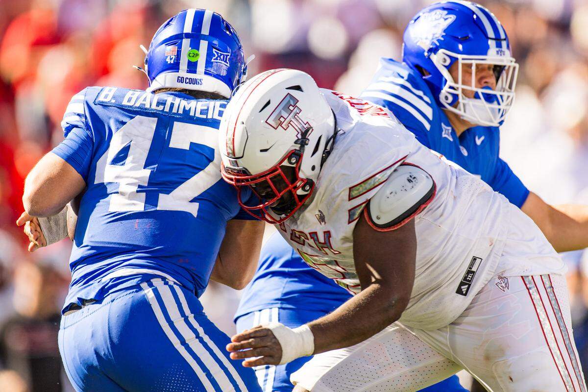 Lee Hunter of the Texas Tech Red Raiders hits Bear Bachmeier (47) of the BYU Cougars during the second half of a November 2025 game in Lubbock, Texas.