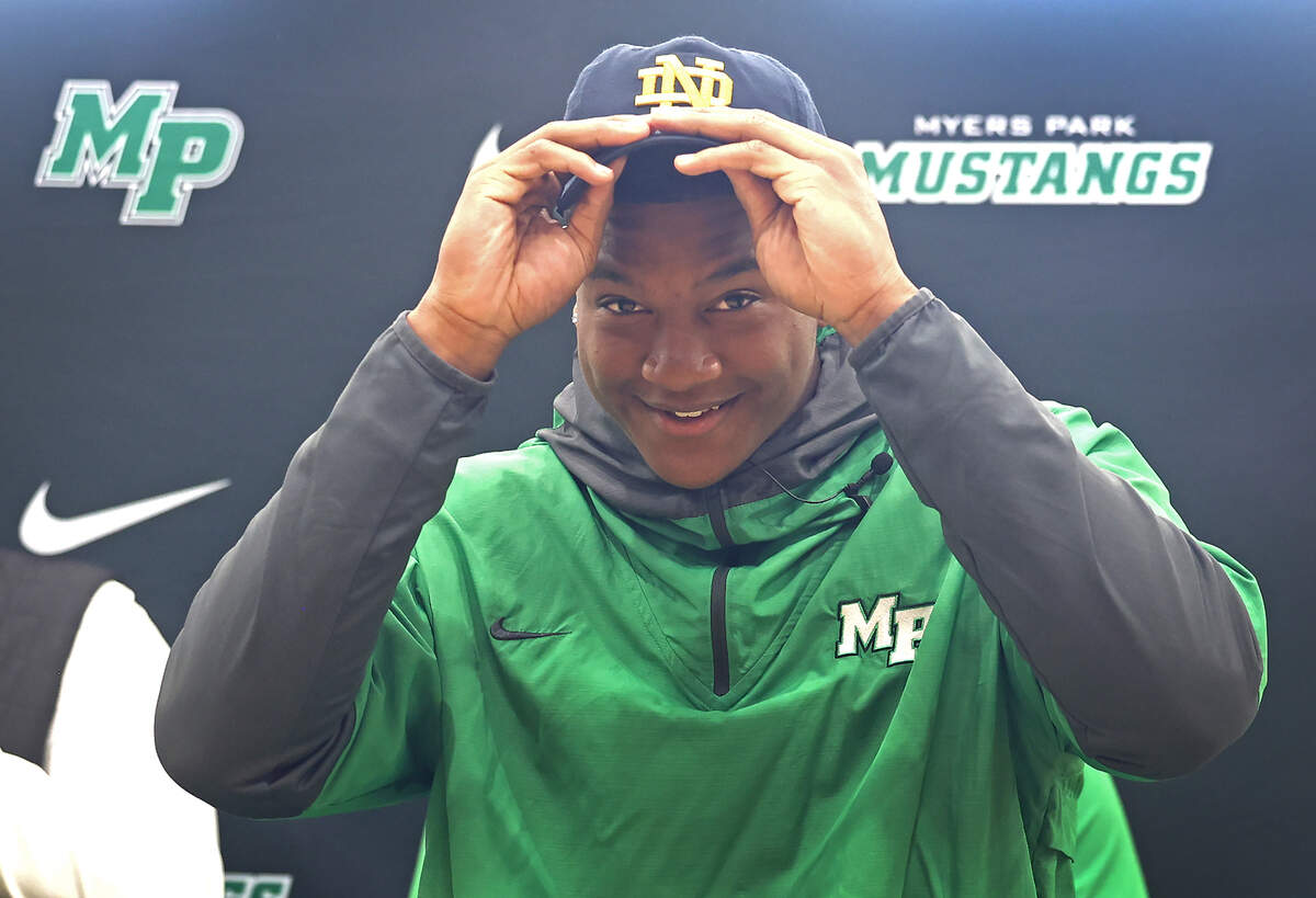 Myers Park High’s Rodney Dunham puts on a Notre Dame cap during his announcement that he will be attending Notre Dame on Thursday, April 10, 2025. Dunham a Top 10 national football recruit had narrowed down his choices to Duke, South Carolina, Georgia, Tennessee and Notre Dame.