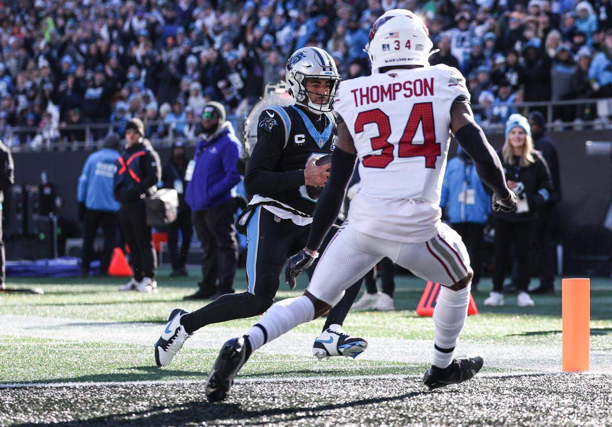 Panthers quarterback Bryce Young, left, runs the ball into the end zone for a touchdown during the game against the Cardinals at Bank of America Stadium in Charlotte, NC on Sunday, December 22, 2024.