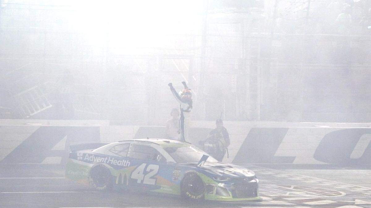 NASCAR driver Kyle Larson celebrates winning Saturday’s NASCAR All-Star race in a cloud of smoke from a burnout at Charlotte Motor Speedway.