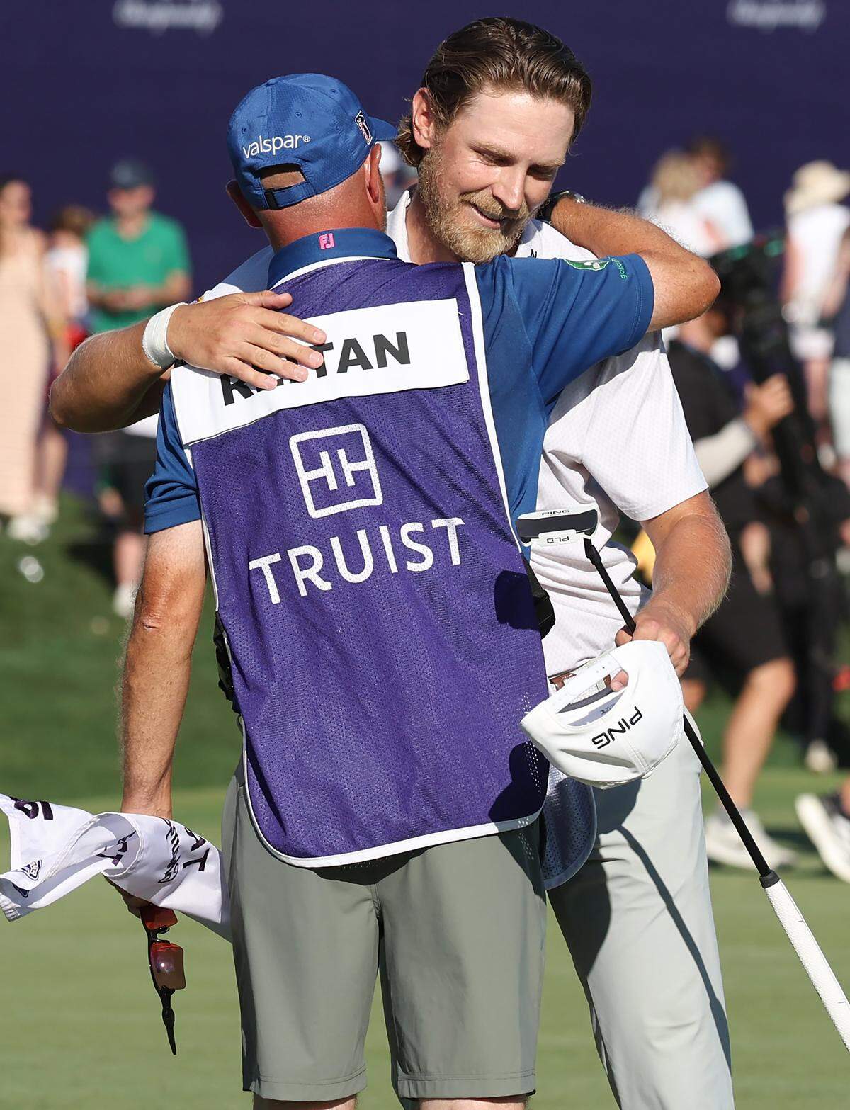 Golfer Kristoffer Reitan, right, hugs his caddie, Tim Poyser, left, after sinking his final putt on the 18th green during final round action of the Truist Championship at Quail Hollow Club in Charlotte, NC on Sunday, May 10, 2026. Reitan won the Truist Championship finishing at -15.