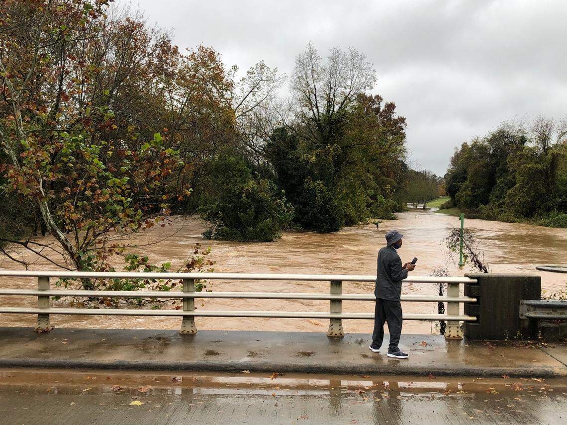 Dwight Little takes photos of the flood waters along Remount Road in Charlotte, NC on Thursday, November 12, 2020. The search will resume on Friday, Nov. 13, 2020, for a 1-year-old and an adult missing from a flood-ravaged campground in Alexander County.