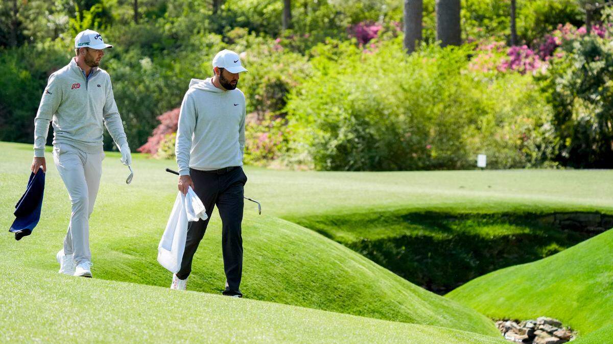 Sam Burns and Scottie Scheffler walk beside Rae’s Creek on No. 13 during a practice round for the Masters Tournament at Augusta National Golf Club.