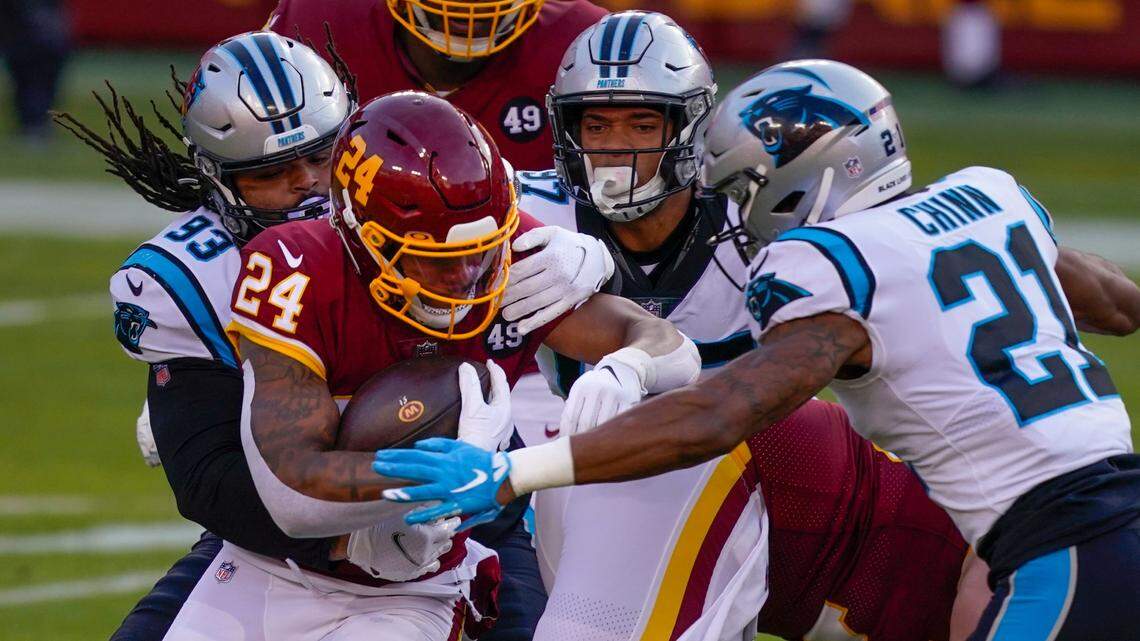 Washington Football Team running back Antonio Gibson (24) is stopped by Carolina Panthers defensive tackle Bravvion Roy (93), defensive end Yetur Gross-Matos (97) and outside linebacker Jeremy Chinn (21) during the first half of an NFL football game, Sunday, Dec. 27, 2020, in Landover, Md. (AP Photo/Mark Tenally)