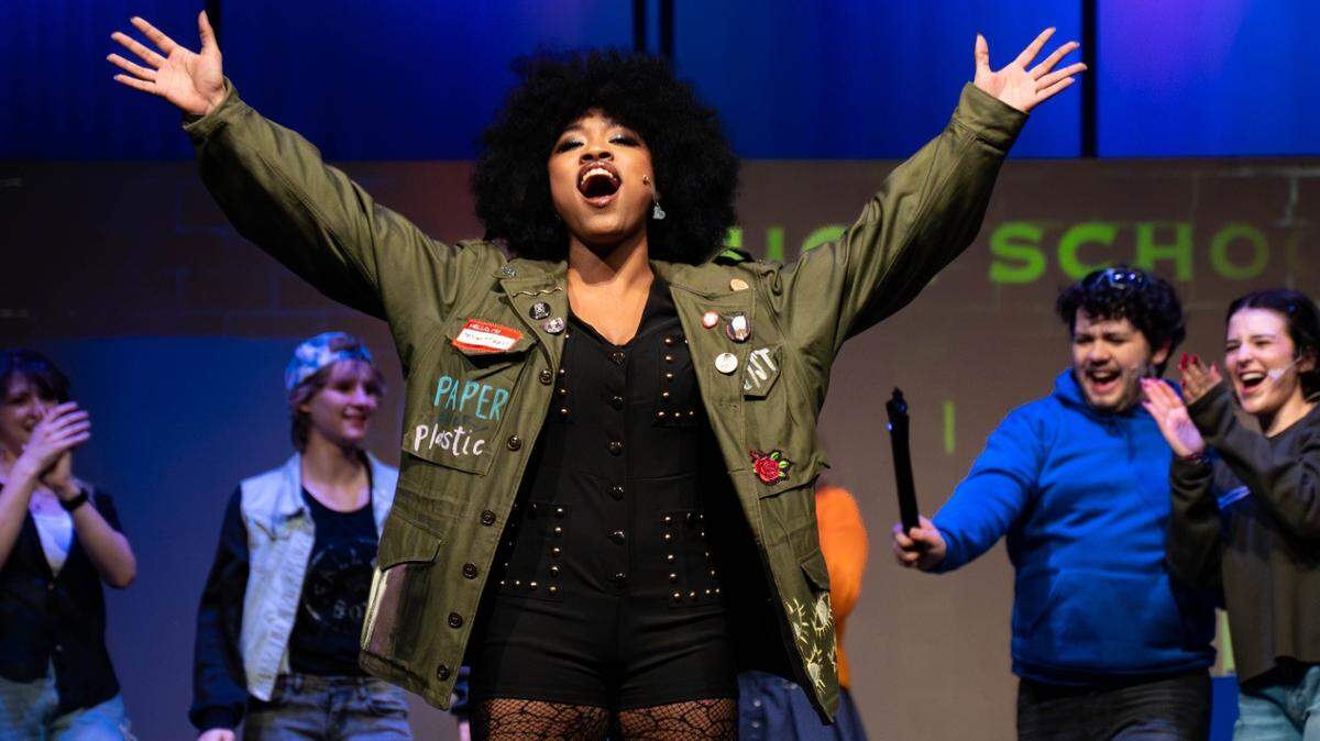 A young woman performs on a stage.