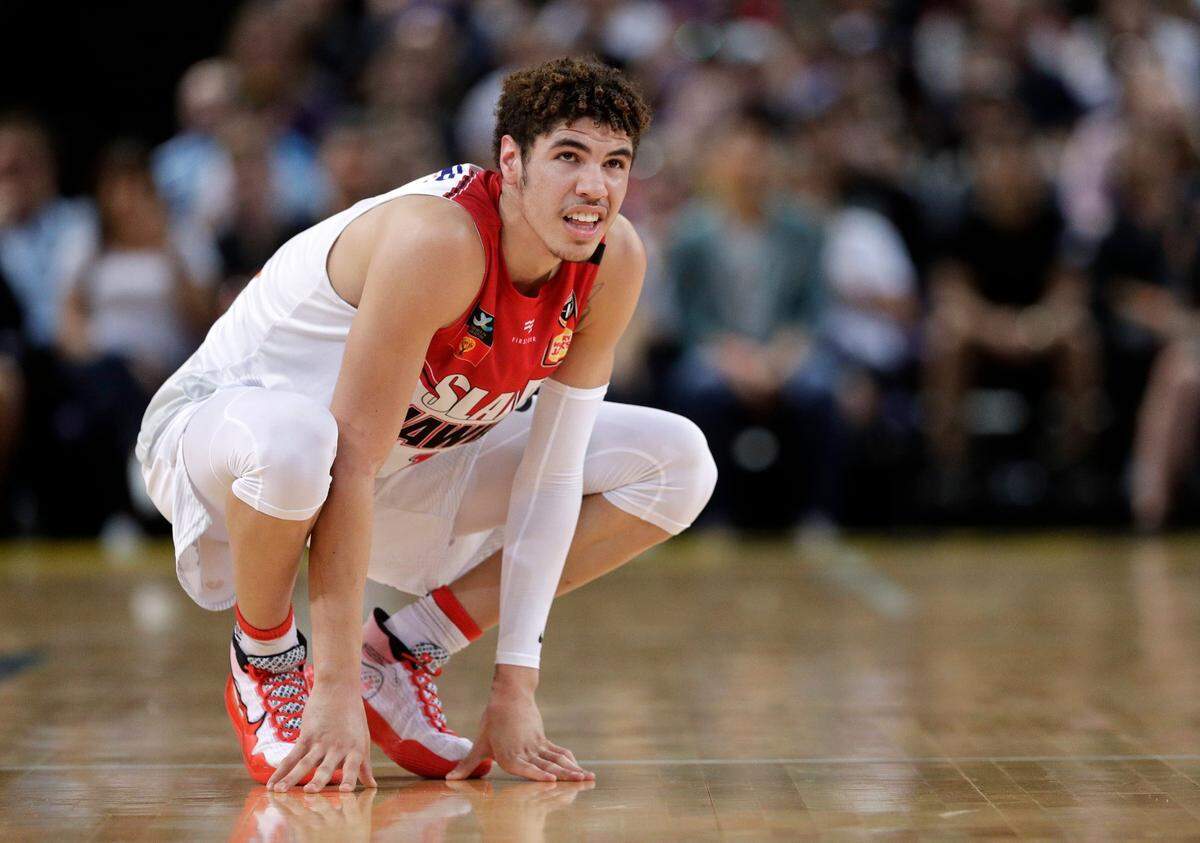 In this Nov. 17, 2019, file photo, LaMelo Ball of the Illawarra Hawks squats during a game in the Australian Basketball League in Sydney. The point guard from California who bypassed college and played overseas is expected to be one of the top three picks when the twice-delayed NBA draft is held Wednesday.